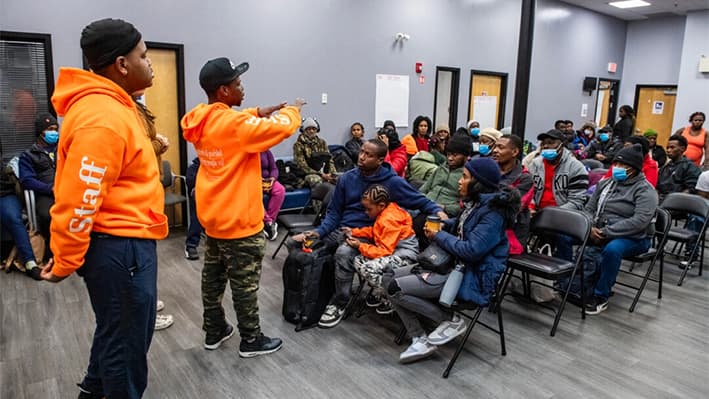 Los trabajadores revisan el programa del día durante una sesión de orientación en el refugio de día en Chelsea, Massachusetts, el 22 de febrero de 2024. (Joseph Prezioso/AFP a través de Getty Images)
