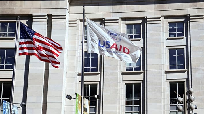 Una bandera estadounidense y una bandera de USAID ondean fuera del edificio de USAID en Washington el 1 de febrero de 2025. (Annabelle Gordon/Reuters)