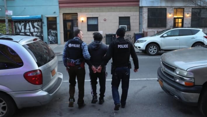 Oficiales del Servicio de Inmigración y Control de Aduanas (ICE) arrestan a un inmigrante ilegal durante una redada en el vecindario Bushwick de Brooklyn, en la ciudad de Nueva York, el 11 de abril de 2018. (John Moore/Getty Images)