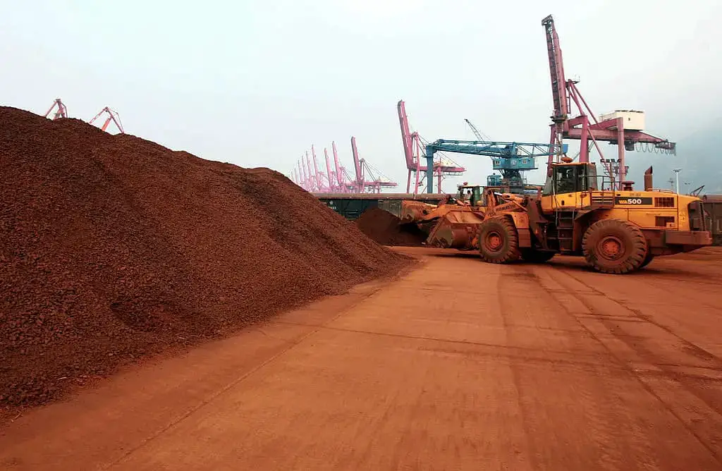 Un hombre que conduce una pala cargadora mueve tierra que contiene minerales de tierras raras para cargarla en un puerto en Lianyungang, provincia de Jiangsu, este de China, para exportarla a Japón, el 5 de diciembre de 2010. (STR/AFP vía Getty Images)