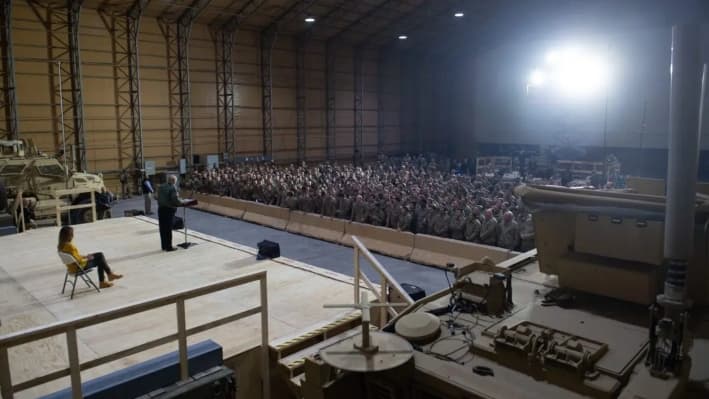El presidente Donald Trump habla con miembros del ejército estadounidense mientras la primera dama, Melania Trump, observa durante un viaje no anunciado a la base aérea de Al Asad, en Irak, el 26 de diciembre de 2018. (Saul Loeb/AFP a través de Getty Images)