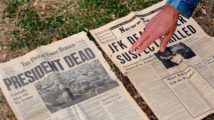 Imagen de archivo de un hombre que muestra un periódico de 1963 que informa sobre el asesinato de Kennedy en el monumento en memoria de John F. Kennedy en Dealey Plaza, el lugar donde fue asesinado, en Dallas, Texas, EE. UU. EFE/Larry W. Smith