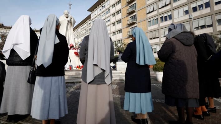 Monjas rezan en el exterior del Hospital Gemelli, donde el Papa Francisco está ingresado para recibir tratamiento, en Roma, Italia, el 23 de febrero de 2025. (Vincenzo Livieri/Reuters)