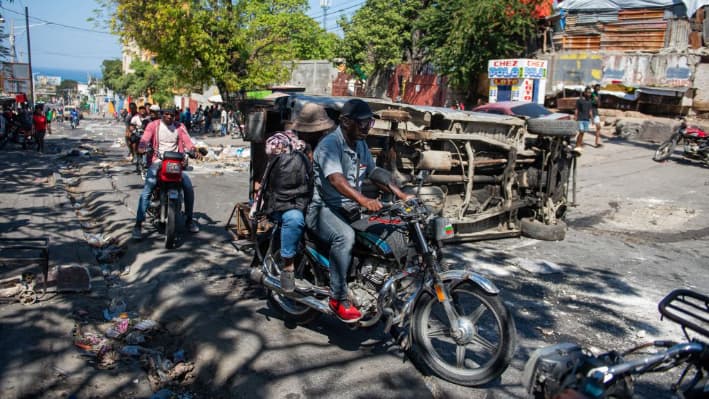 La gente huye de la violencia de pandillas en un barrio de Puerto Príncipe mientras la gente se manifiesta contra el gobierno el 20 de febrero de 2025. (Clarens Siffroy/AFP vía Getty Images)
