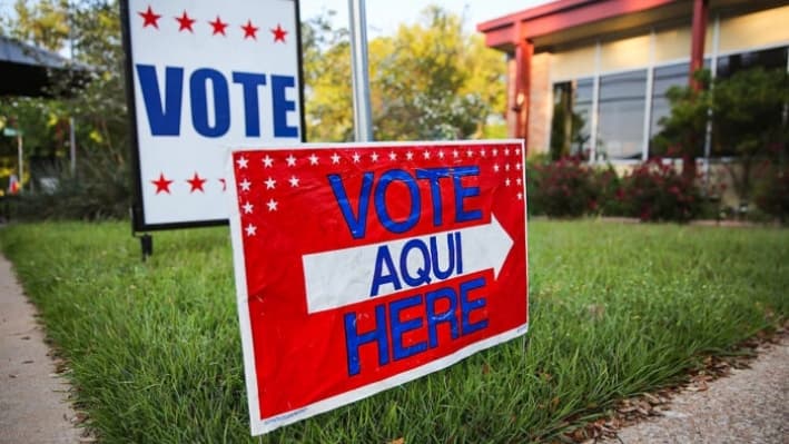 Un cartel bilingüe se encuentra afuera de un centro de votación en una biblioteca pública en Austin, Texas, antes de las elecciones locales del 28 de abril de 2013. (John Moore/Getty Images)