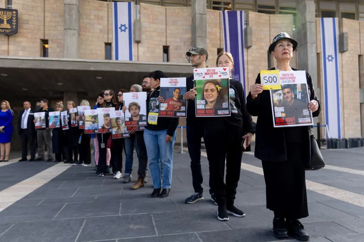 Familiares y simpatizantes de los rehenes que siguen retenidos en la Franja de Gaza sostienen 73 carteles de ellos a la entrada del Parlamento israelí el 17 de febrero de 2025, para conmemorar los 500 días de cautiverio. (Amir Levy/Getty Images)