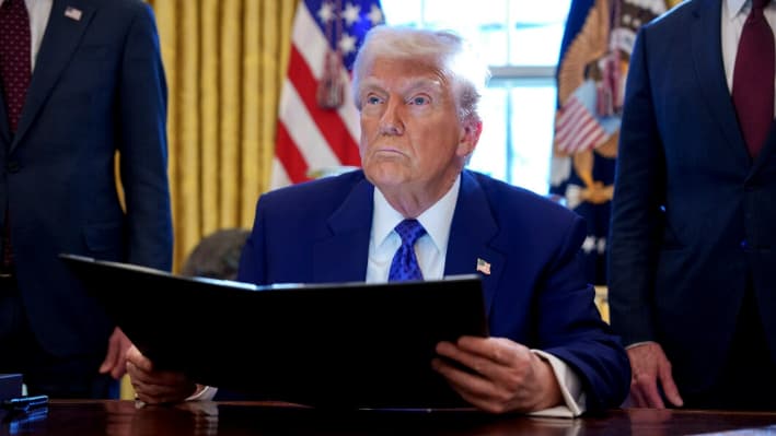 El presidente Donald Trump sostiene una orden ejecutiva que establece el Consejo de Dominio Energético dirigido por el secretario de Interior Doug Burgum en el Despacho Oval de la Casa Blanca el 14 de febrero de 2025. (Andrew Harnik/Getty Images)