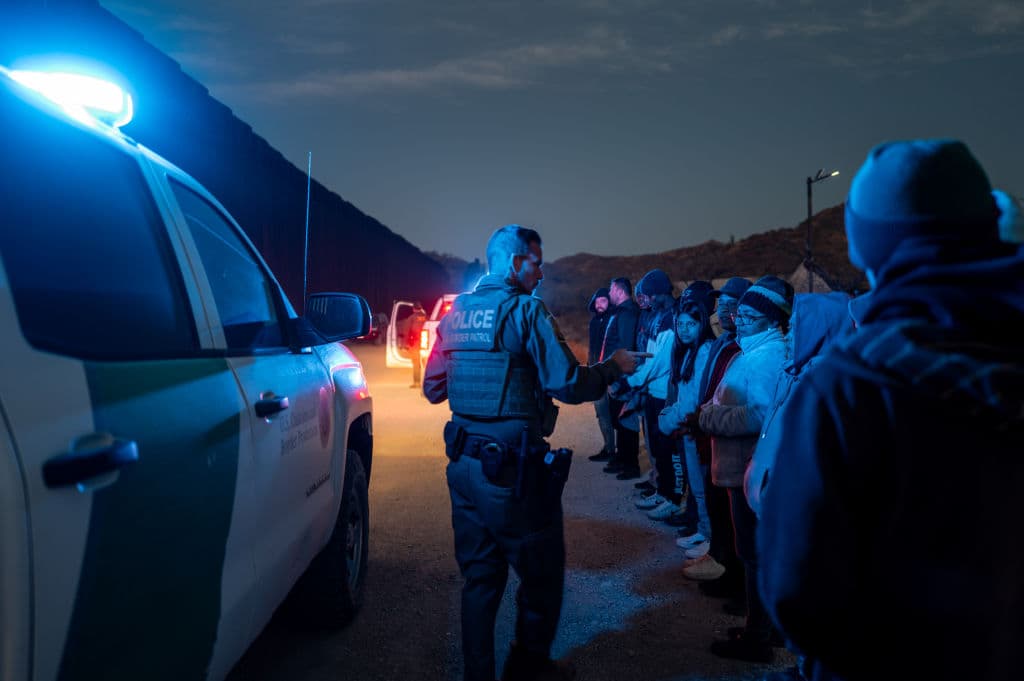 Migrantes de México y Guatemala son detenidos por agentes estadounidenses después de cruzar una sección del muro fronterizo hacia Estados Unidos, el 4 de enero de 2025 en Ruby, Arizona. (Brandon Bell/Getty Images)