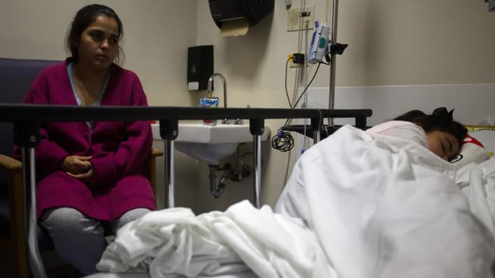 Fotografía de archivo, tomada el pasado 17 de agosto, en la que se registró a una madre (i) junto a su hija de 9 años hospitalizada por dengue en el Hospital Auxilio Mutuo de San Juan (Puerto Rico). EFE/Thais Llorca