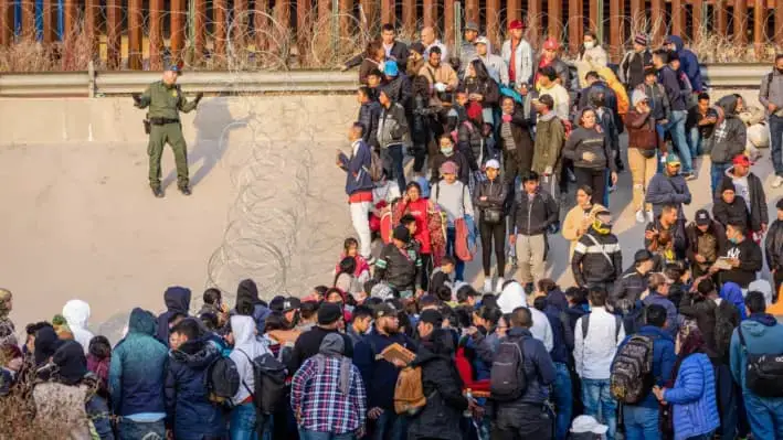 Un agente de la Patrulla Fronteriza de Estados Unidos habla con inmigrantes ilegales en El Paso, Texas, el 20 de diciembre de 2022. (John Moore/Getty Images)