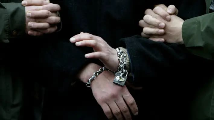 Las manos esposadas se ven en una foto de archivo. (Mustafa Ozer/AFP vía Getty Images)