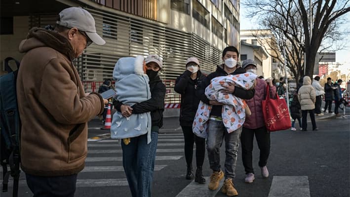 Personas con sus hijos salen de un hospital infantil en Pekín el 10 de enero de 2025. (Jade Gao/AFP a través de Getty Images)
