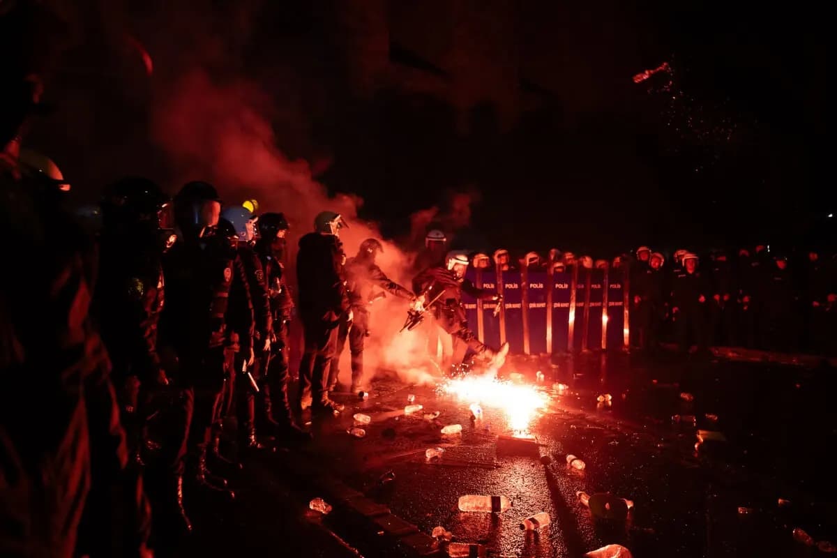 Agentes de la policía antidisturbios turca devuelven una bengala lanzada por los manifestantes durante los enfrentamientos en una manifestación cerca del ayuntamiento de Estambul el 21 de marzo de 2025. (Ozan Kose/AFP a través de Getty Images)