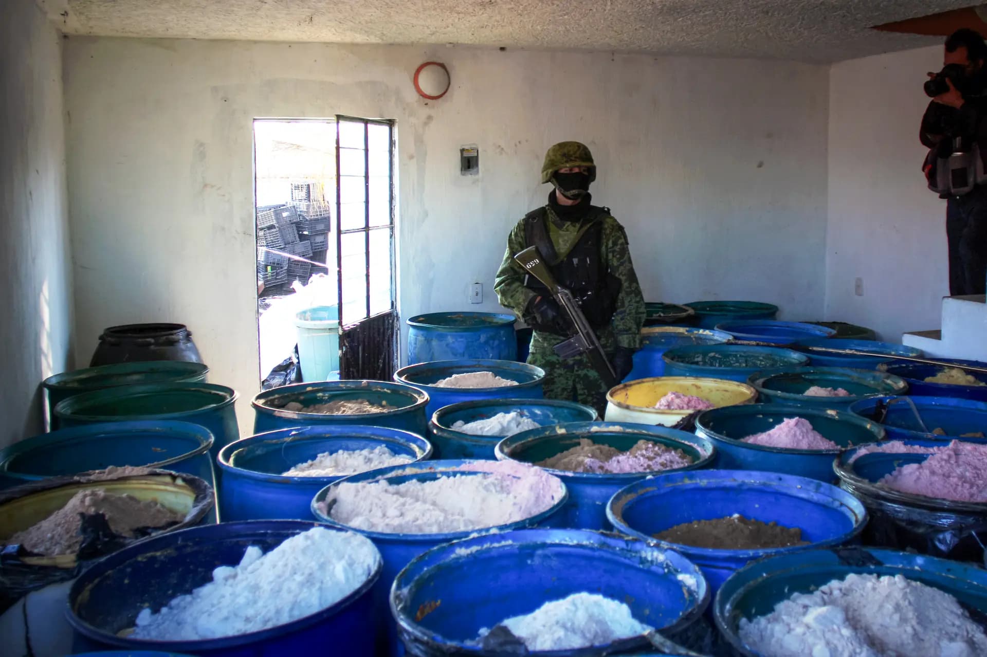 Un soldado hace guardia dentro de un laboratorio clandestino de procesamiento de drogas químicas descubierto en Tlajomulco de Zúñiga, México, el 9 de febrero de 2012. Las bandas chinas suministran a los cárteles mexicanos productos químicos para crear drogas ilícitas que se venden en Estados Unidos. (Hector Guerrero/AFP a través de Getty Images).