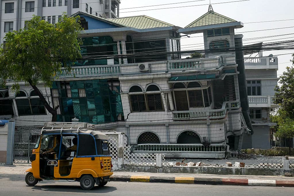 Un tuk-tuk pasa junto a un edificio dañado en Mandalay el 29 de marzo de 2025, un día después de que un terremoto sacudiera el centro de Myanmar.(Sai Aung Main/AFP vía Getty Images)
