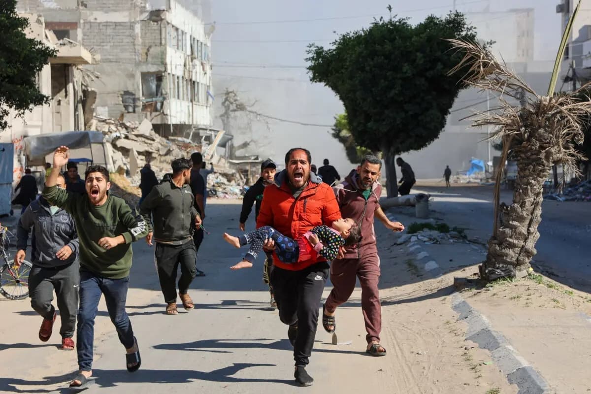 Los palestinos sacan a toda prisa a una niña herida del lugar de los ataques israelíes en un campamento de desplazados improvisado en el centro de la ciudad de Gaza el 23 de marzo de 2025. (Omar Al-Qattaa/AFP a través de Getty Images)
