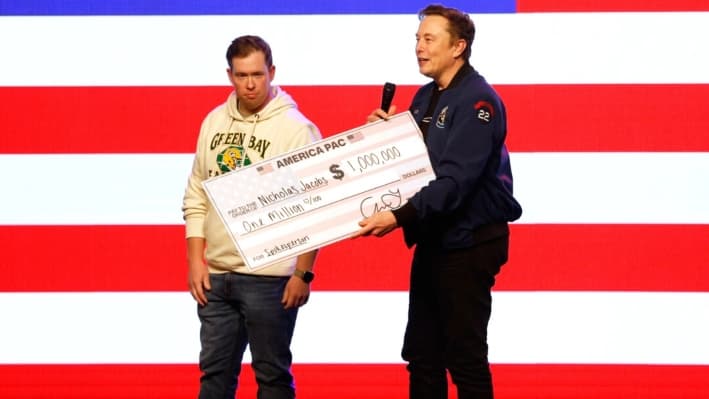 Elon Musk presenta un cheque por un millón de dólares durante un foro ciudadano en Green Bay, Wisconsin, el 30 de marzo de 2025. (Jeffrey Phelps/AP Photo)