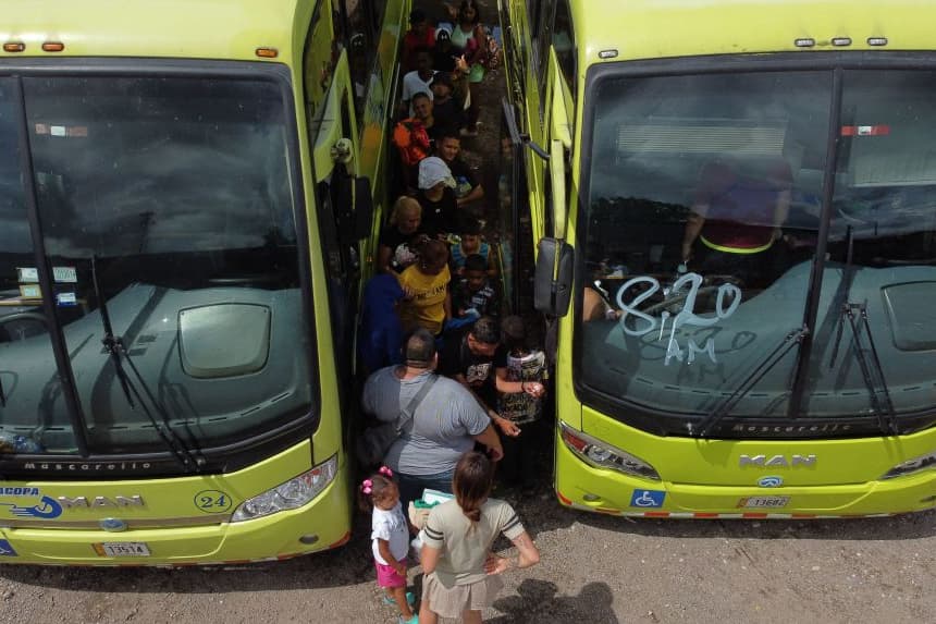 Personas migrantes esperan para abordar un autobús en un campamento de refugiados en Paso Canoa, en la región de Puntarenas, Costa Rica, el 9 de agosto de 2023. (Alberto Pena/AFP vía Getty Images)
