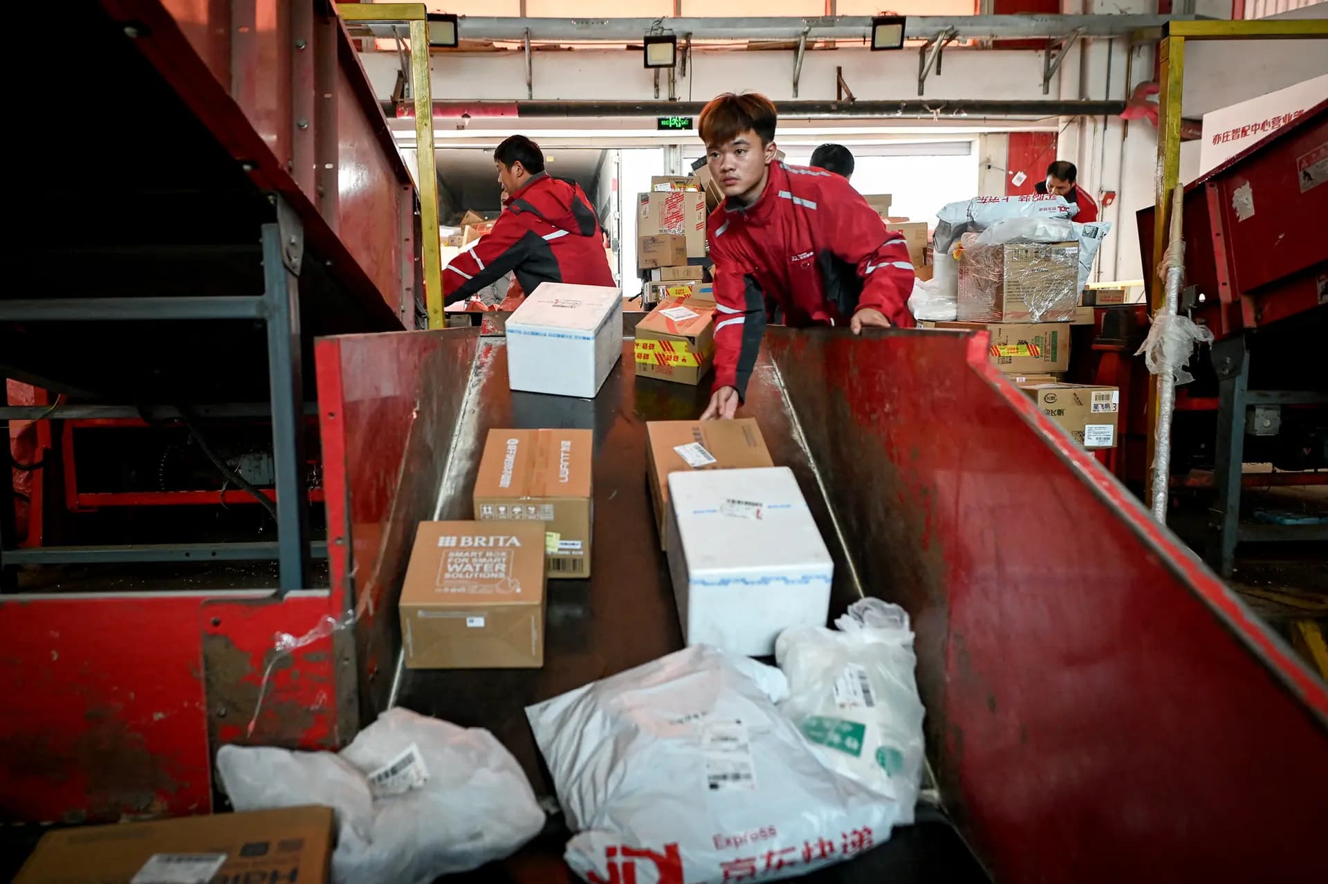 Trabajadores clasifican paquetes para su entrega en un almacén de JD.com en Beijing el 11 de noviembre de 2024. Más de una docena de gigantes minoristas chinos, entre ellos JD.com, anunciaron medidas para aliviar la presión sobre los exportadores. (Wang Zhao/AFP vía Getty Images).