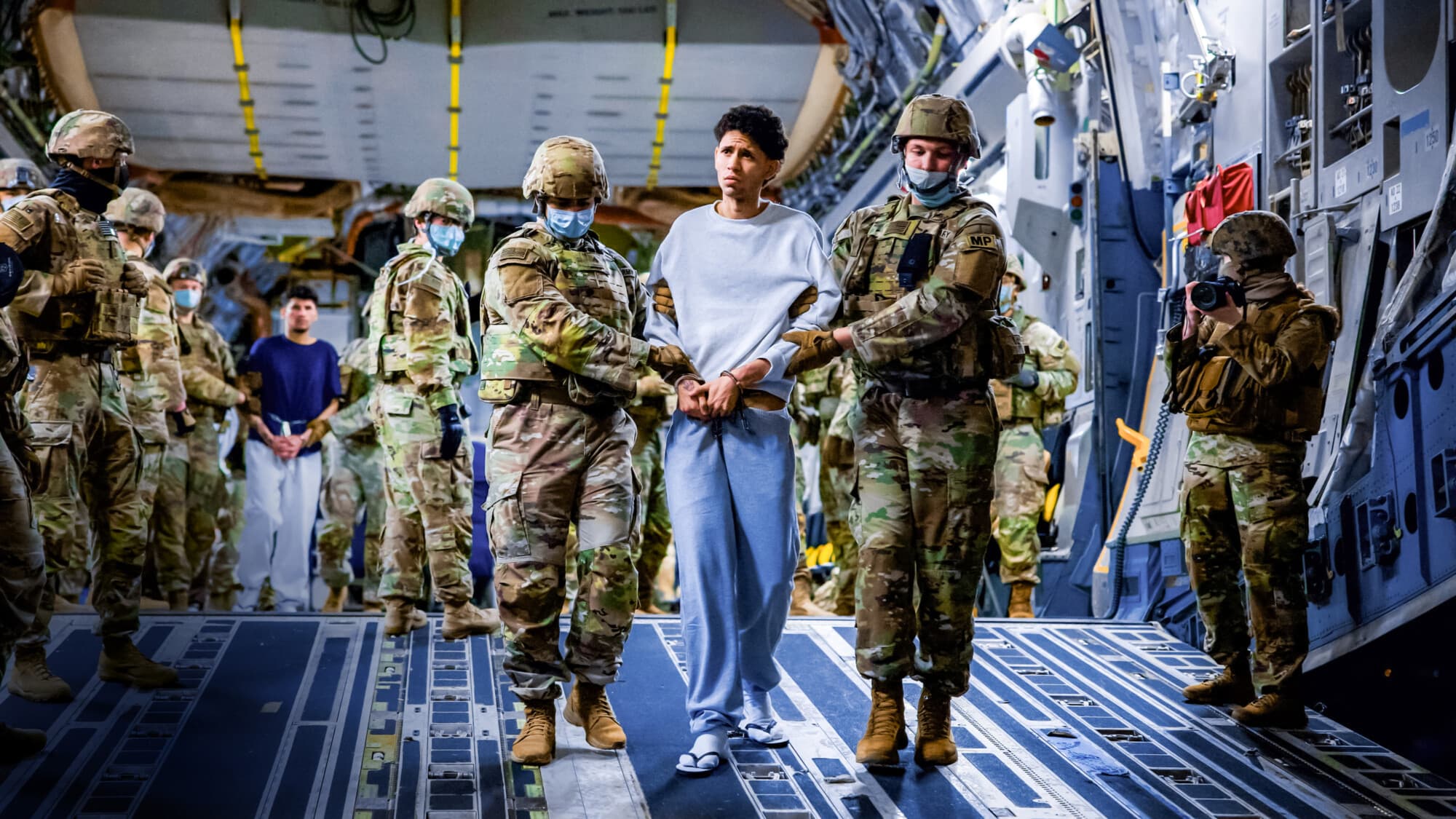 Personal militar estadounidense escolta a presuntos miembros de la banda venezolana Tren de Aragua y la banda MS-13 recientemente deportados por el Gobierno de Estados Unidos para ser encarcelados en el Centro de Confinamiento por Terrorismo (CECOT), como parte de un acuerdo con el Gobierno salvadoreño, en San Luis Talpa, El Salvador, el 30 de marzo de 2025. (Secretaría de Prensa de la Presidencia/Handout vía Reuters).