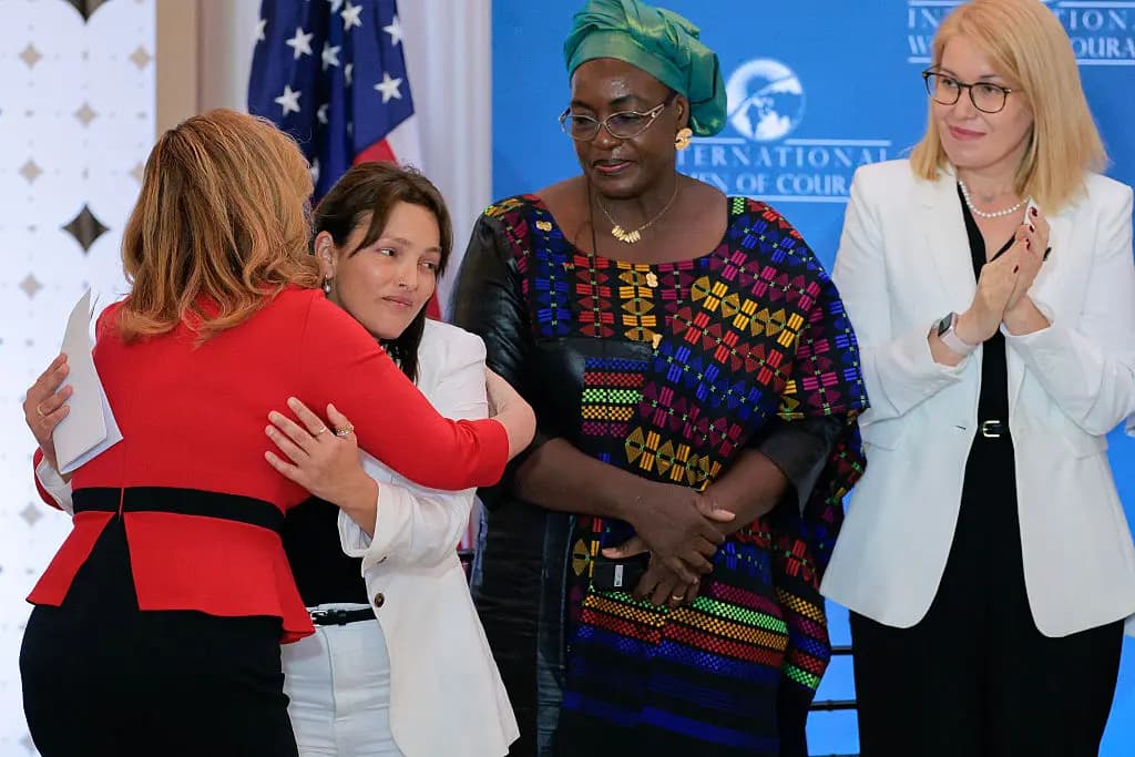 <em>Amit Soussana (2.º por la izquierda), rehén del ataque terrorista de Hamás del 7 de octubre en Israel, recibe un abrazo de Katrina «Kat» Fotovat después de que Soussana, la defensora de los derechos humanos Henriette Da de Burkina Faso (C) y la defensora de la salud mental rumana Georgiana Pascu recibieran el Premio Internacional a las Mujeres de Coraje durante una ceremonia con la primera dama Melania Trump en la Sala Ben Franklin de la sede del Departamento de Estado Harry S. Truman en Washington el 1 de abril de 2025. Chip Somodevilla/Getty Images</em>