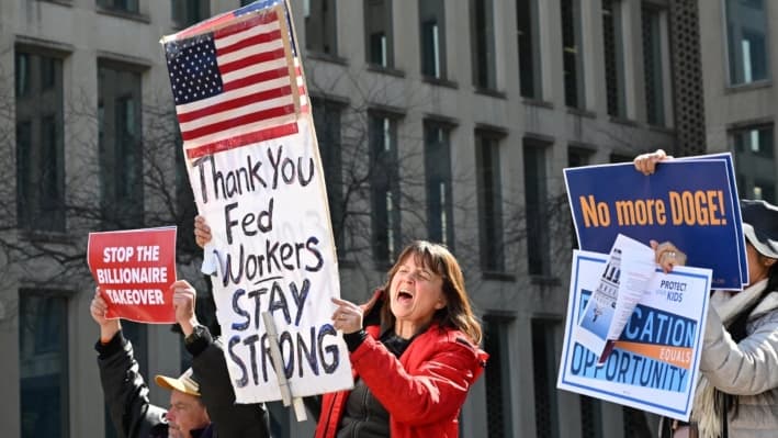 Manifestantes sostienen carteles en una manifestación en apoyo a los trabajadores federales en la Oficina de Administración de Personal en Washington, el 4 de marzo de 2025. (Alex Wroblewski/AFP vía Getty Images)
