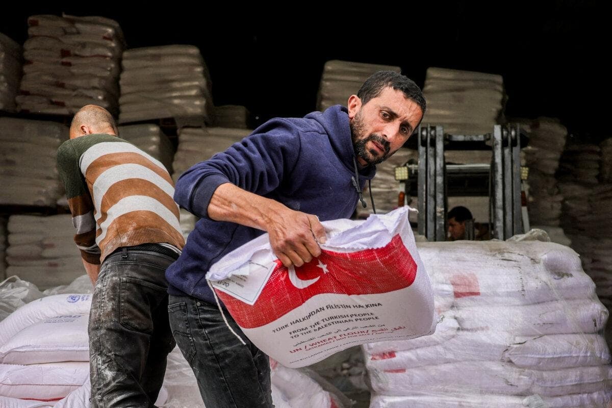La gente recibe sacos de harina proporcionados por la agencia turca de ayuda en casos de desastre AFAD en el barrio de al-Tifah de la ciudad de Gaza el 1 de abril de 2025. (Bashar Taleb/AFP a través de Getty Images)
