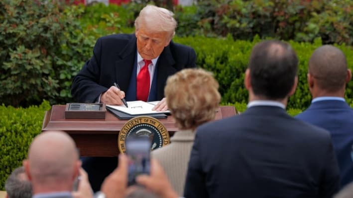 El presidente Donald Trump firma órdenes ejecutivas que aumentan los aranceles a productos fabricados en países extranjeros durante el evento "Hagamos que Estados Unidos vuelva a ser rico" en el jardín de rosas de la Casa Blanca, el 2 de abril de 2025. (Chip Somodevilla/Getty Images)