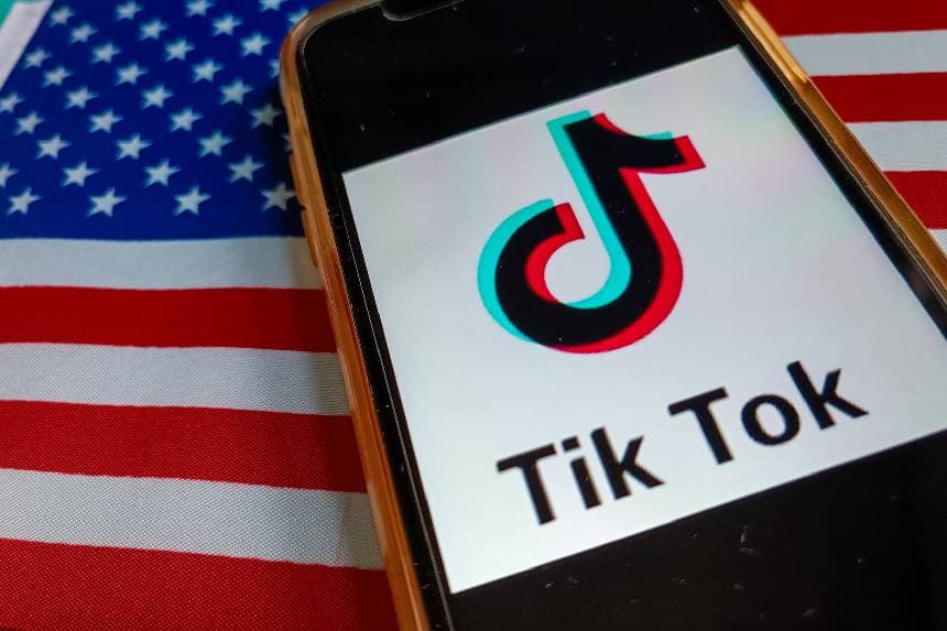El logotipo de TikTok se muestra en un teléfono con la bandera de EE. UU. en una foto de archivo. (Riccardo Milani/Hans Lucas/AFP a través de Getty Images).