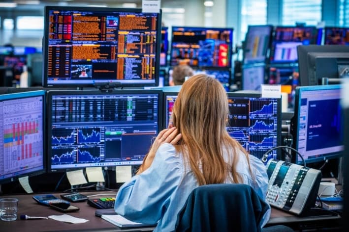 Empleados en la sala de operaciones de Nordea Markets observan la agitación y las fuertes caídas del mercado bursátil tras los aranceles que afectan a los mercados de todo el mundo, en Oslo, Noruega, el 7 de abril de 2025. (OLE BERG-RUSTEN/NTB/AFP vía Getty Images)