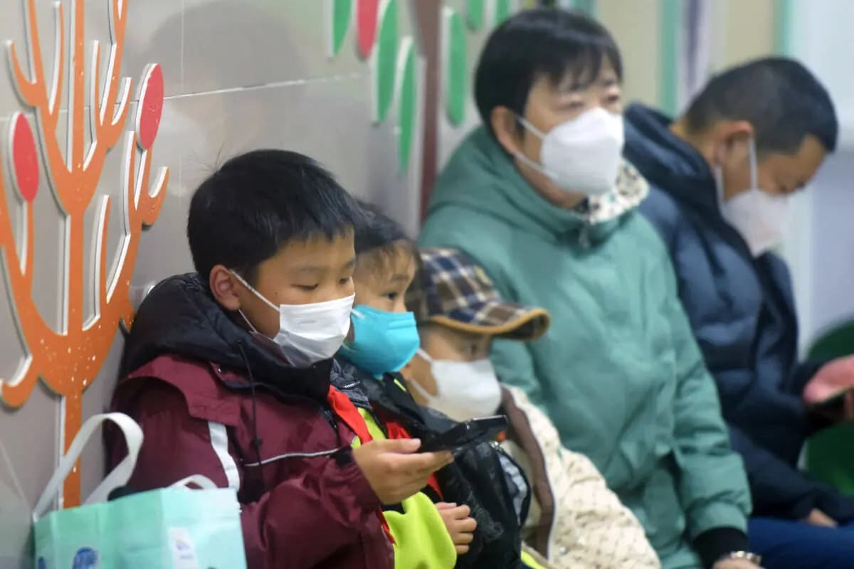 Niños con cubrebocas, acompañados por adultos, esperan a ser atendidos por el personal médico en el departamento de pediatría de un hospital en Hangzhou, provincia de Zhejiang, en el este de China, el 6 de enero de 2025. (AFP a través de Getty Images)