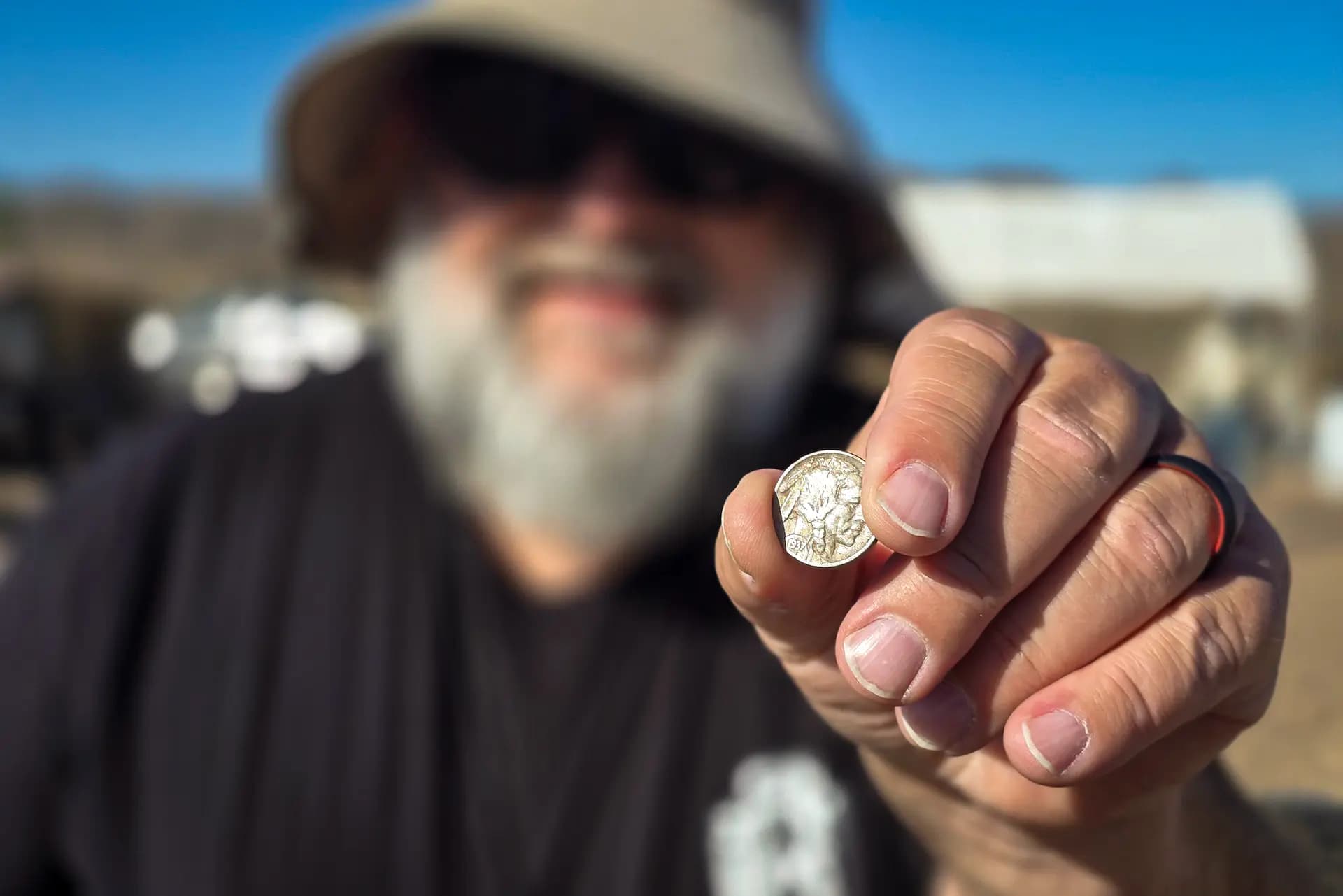 <em>Bob Burgette, de 62 años, sostiene la moneda de níquel de 1937 con la cabeza de un indio que encontró con su detector de metales Minelab durante la excursión anual de primavera del club Desert Gold Diggers, cerca de Tucson, Arizona, el 22 de marzo de 2025. Allan Stein/The Epoch Times</em>