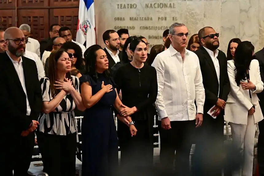 Familiares del cantante Rubby Pérez, el presidente de República Dominicana, Luis Abinader (3-d) y su esposa, Raquel Arbaje (4-i), asisten al velorio del afamado merenguero, quien falleció tras el derrumbe del techo de la discoteca Jet Set donde se presentaba, en el Teatro Nacional de Santo Domingo el 10 de abril de 2025. (Martin Bernetti/AFP vía Getty Images)