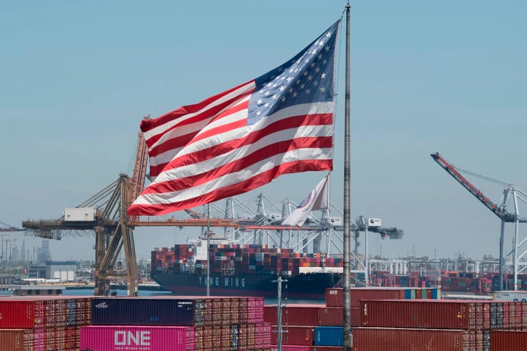 La bandera de EE. UU. ondea sobre un buque de carga que desembarca mercancías procedentes de Asia en el puerto de Long Beach, California, el 1 de agosto de 2019. (Mark Ralston/AFP a través de Getty Images).