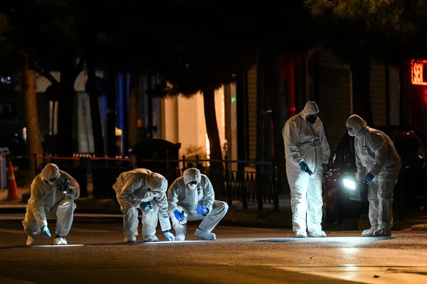 Expertos de la policía griega buscan evidencias tras la explosión de una bomba frente a las oficinas de Hellenic Train en Atenas el 11 de abril de 2025. (Angelos Tzortzinis/AFP vía Getty Images)