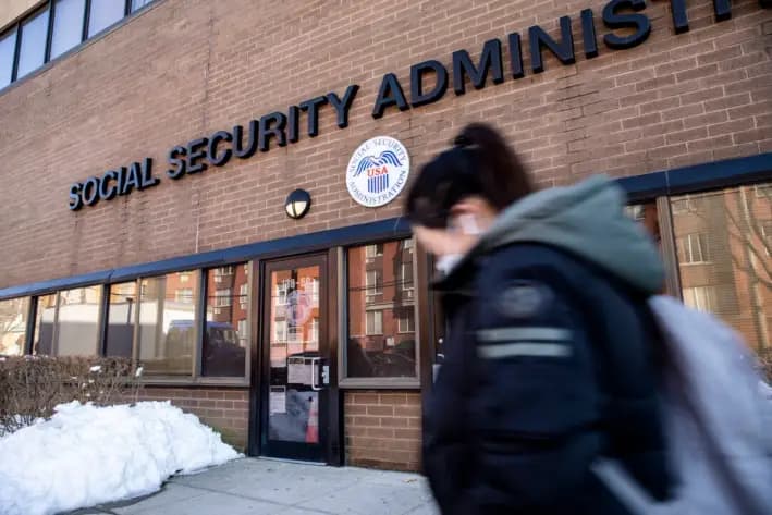 Una mujer con mascarilla protectora pasa junto a una oficina de la Administración del Seguro Social durante la pandemia del virus del PCCh, en Flushing, Nueva York, el 10 de febrero de 2021. (Chung I Ho/The Epoch Times)