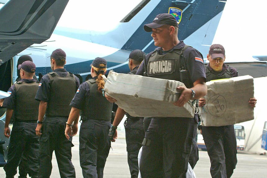 Miembros de la policía costarricense descargan el 24 de abril de 2005, en el aeropuerto Juan Santamaría de Alajuela, a 20 kilómetros de San José, parte de cocaína incautados. (STR/AFP vía Getty Images)