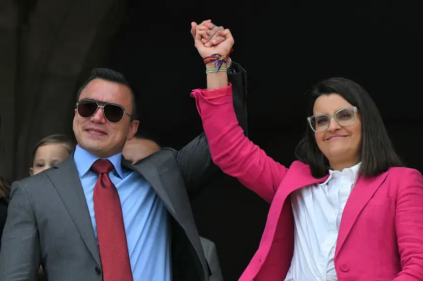 El presidente reelecto de Ecuador, Daniel Noboa, y la vicepresidenta reelecta, María José Pinto, se toman de la mano desde un balcón del Palacio Presidencial de Carondelet durante la ceremonia de cambio de guardia en Quito (Ecuador) el 15 de abril de 2025. (Rodrigo Buendia/AFP vía Getty Images)