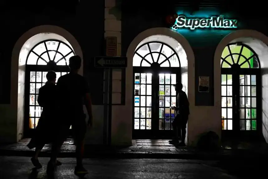 Personas caminan frente a una tienda durante un apagón el 16 de abril de 2025, en San Juan (Puerto Rico). EFE/ Thais Llorca