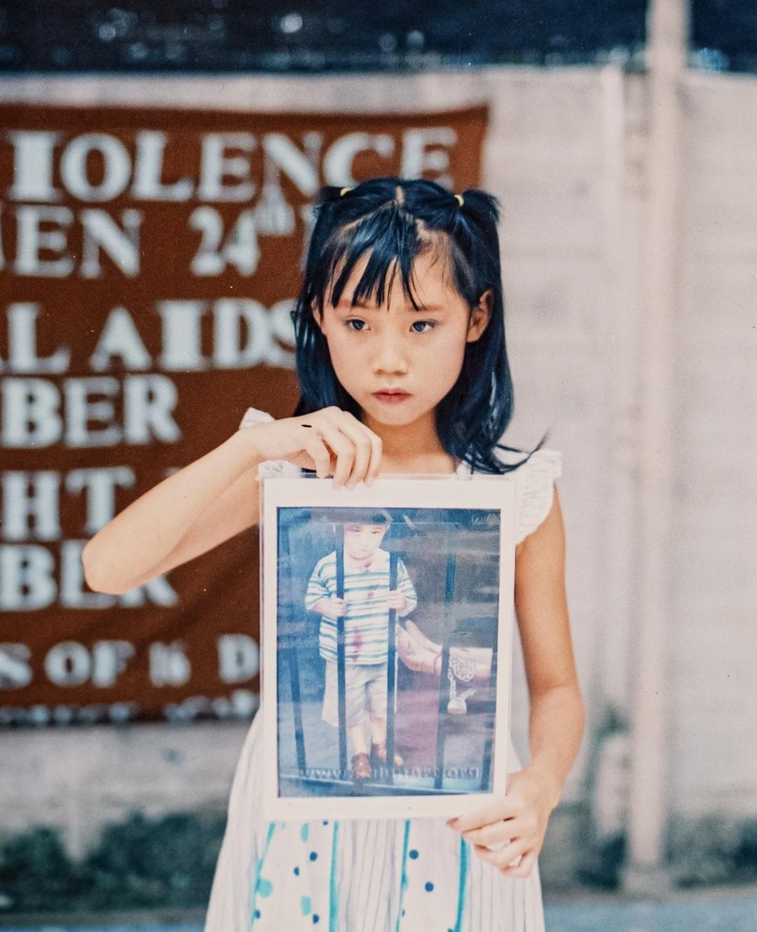 Ellie Rao sostiene una foto de una obra de arte que representa la persecución a Falun Gong. (Samira Bouaou/The Epoch Times)