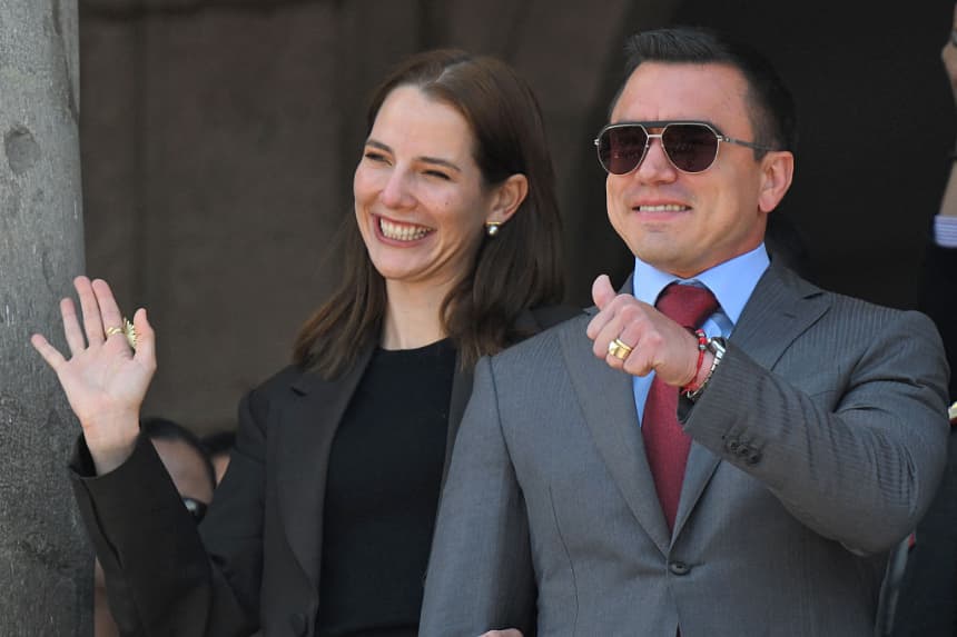 El presidente reelegido de Ecuador, Daniel Noboa (d), hace un gesto con el pulgar hacia arriba junto a su esposa, Lavinia Valbonesi, desde un balcón del Palacio Presidencial de Carondelet durante la ceremonia de cambio de guardia en Quito el 15 de abril de 2025. (Rodrigo Buendia/AFP vía Getty Images)