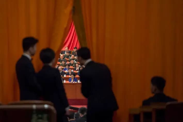 Guardias de seguridad chinos observan a delegados militares durante el discurso del líder chino Xi Jinping en el XIX Congreso del Partido Comunista, en Beijing, el 18 de octubre de 2017. (Fred Dufour/AFP vía Getty Images)