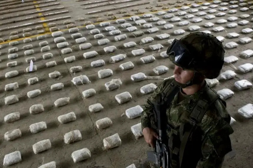 Un soldado del Ejército colombiano junto a paquetes de cocaína incautados durante una conferencia de prensa en una base militar en Bahía Solano, departamento del Chocó, Colombia, el 14 de marzo de 2015. (Luis Robayo/AFP vía Getty Images)