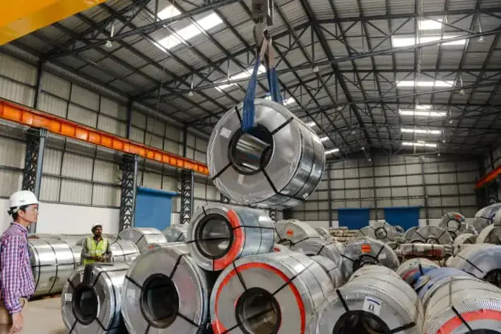 Trabajadores indios almacenan bobinas de acero cerca de Viramgam, India, el 27 de enero de 2016. (SAM PANTHAKY/AFP vía Getty Images)