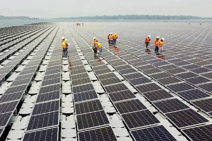 Trabajadores caminan entre paneles de células solares sobre la superficie del agua de la presa Sirindhorn en Ubon Ratchathani, Tailandia, el 8 de abril de 2021. (Prapan Chankaew/Reuters).