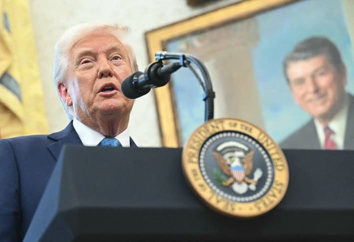 Un retrato del 40.º presidente de Estados Unidos, Ronald Reagan, se ve al fondo mientras el presidente, Donald Trump, habla con los periodistas durante la ceremonia de juramentación de Paul Atkins, presidente de la Comisión de Bolsa y Valores (SEC), en la Oficina Oval de la Casa Blanca, en Washington, D.C., el 22 de abril de 2025. (Saul Loeb/AFP vía Getty Images)
