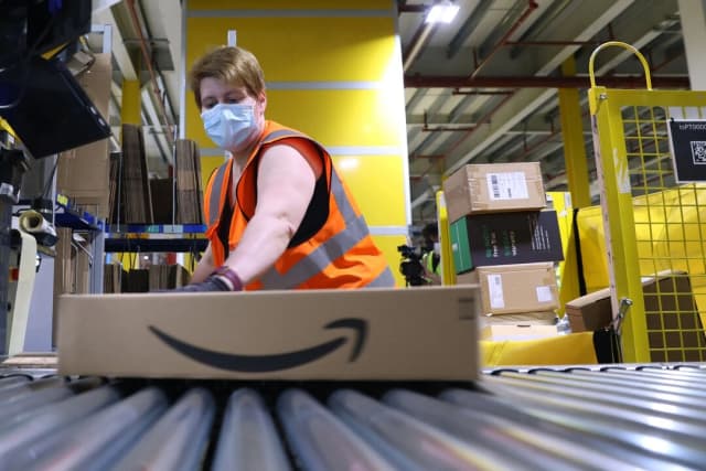 Un empleado prepara un paquete para su envío en el centro logístico de Amazon en Suelzetal, al este de Alemania, el 12 de mayo de 2021. (Ronny Hartmann/AFP a través de Getty Images).
