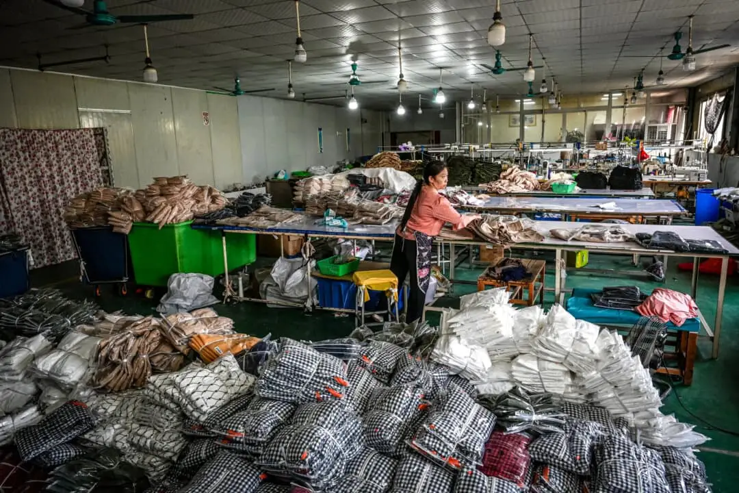 Trabajadora empaqueta prendas para la empresa china de comercio electrónico Temu en una fábrica de ropa en Guangzhou, en la provincia de Guangdong, al sur de China, el 16 de abril de 2025. (Jade Gao/AFP a través de Getty Images)