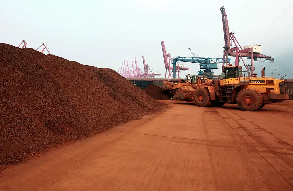 En una fotografía tomada el 5 de septiembre de 2010, un hombre que conduce una pala cargadora traslada tierra que contiene minerales de tierras raras para su exportación a Japón en un puerto de Lianyungang, en la provincia de Jiangsu, al este de China. (STR/AFP a través de Getty Images)