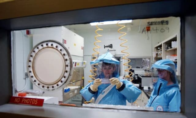 Personal trabajando en el laboratorio de bioseguridad de nivel 4 del Instituto de Investigación Médica de Enfermedades Infecciosas del Ejército de los Estados Unidos en Fort Detrick, el 26 de septiembre de 2002. (Olivier Douliery/AFP a través de Getty Images)